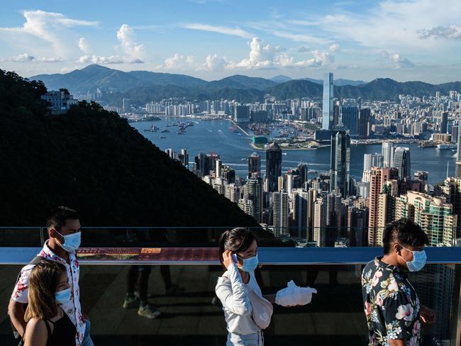 (FILES) In this file photo taken on July 28, 2020, visitors walk along a viewing platform on Victoria Peak in Hong Kong. - Hong Kong and Singapore announced on April 26, 2021 plans to resurrect their scrapped coronavirus travel bubble with dedicated flights between the two cities starting on May 26. (Photo by ANTHONY WALLACE / AFP)