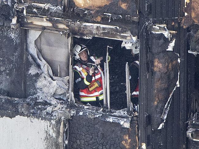 A firefighter checks damage after a fire engulfed the 24-storey Grenfell Tower. Picture: Rick Findler/PA via AP