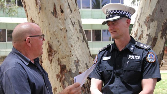 Department of the Chief Minister and Cabinet senior executive director John Gaynor talks to Northern Territory Police southern commander James Gray-Spence out the front of Alice Springs police station. Picture: Gera Kazakov