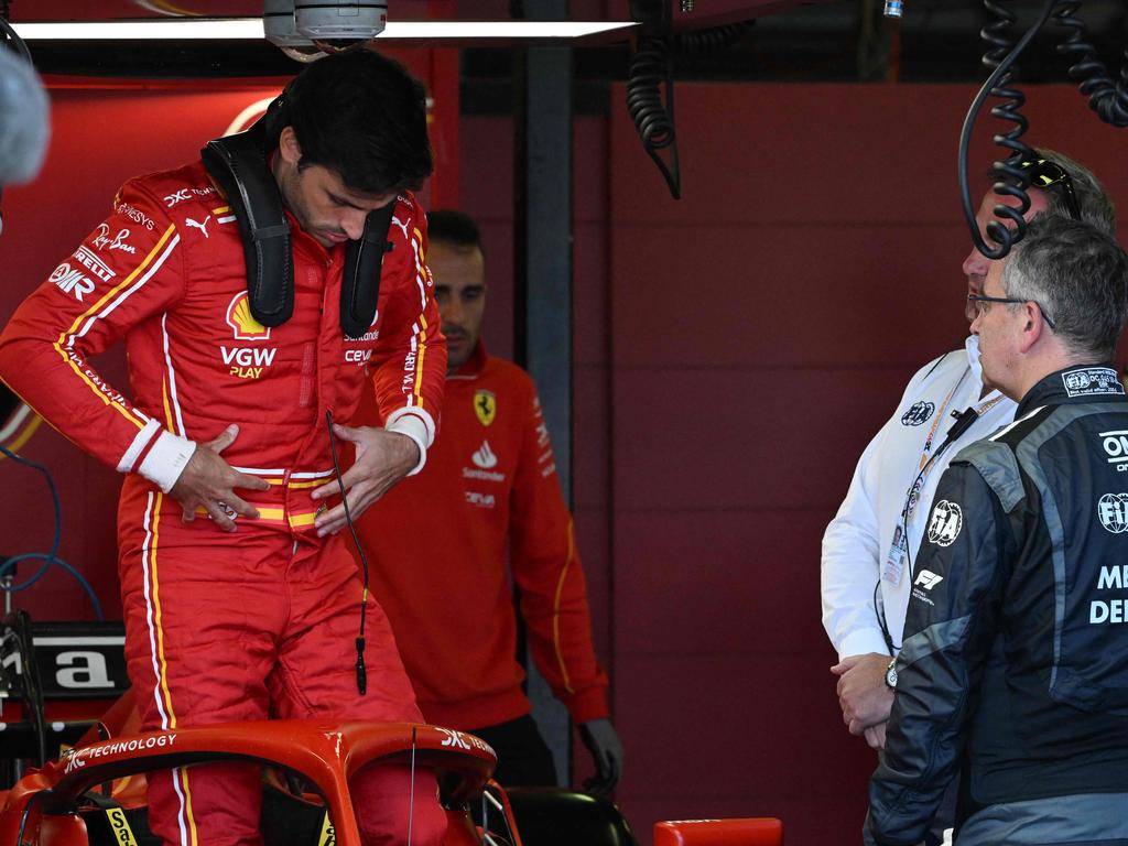 Carlos Sainz discusses with a FIA medical delegate following his return after appendicitis surgery.