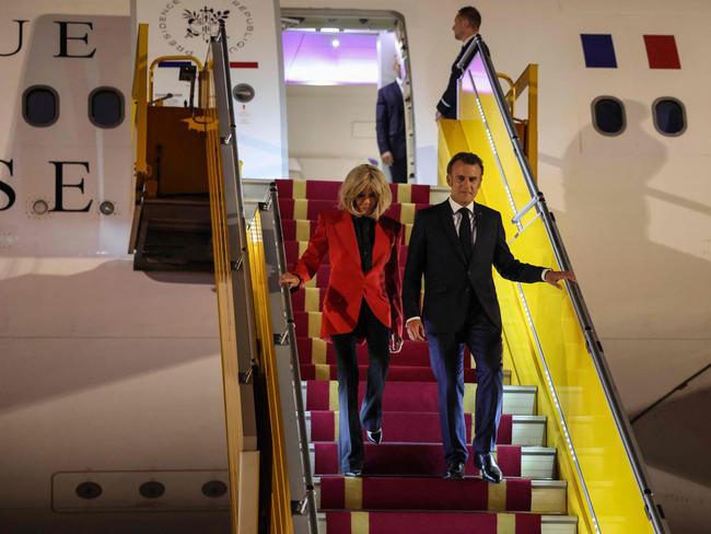 Emmanuel Macron and wife Brigitte make their way down the plane’s steps. Picture: AFP