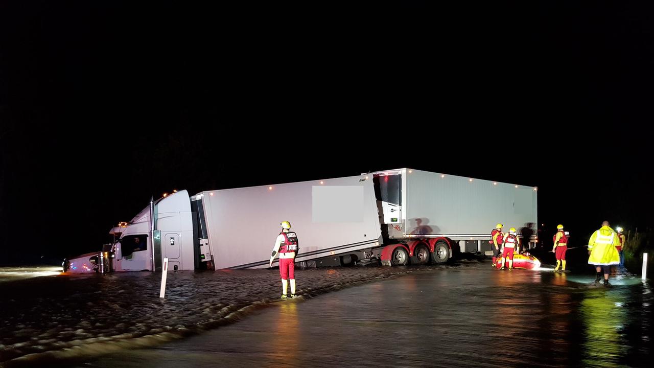 A truck driver was rescued from floodwaters by emergency crews after rolling on a Goondiwindi highway. Picture QFES Media