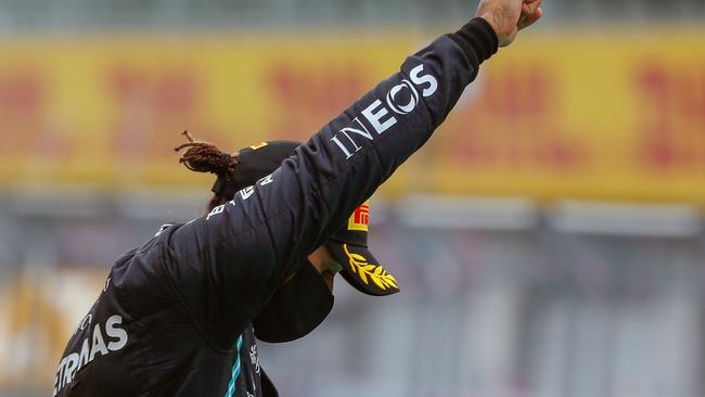 Mercedes' British driver Lewis Hamilton raises a fist on the podium after the Formula One Styrian Grand Prix.