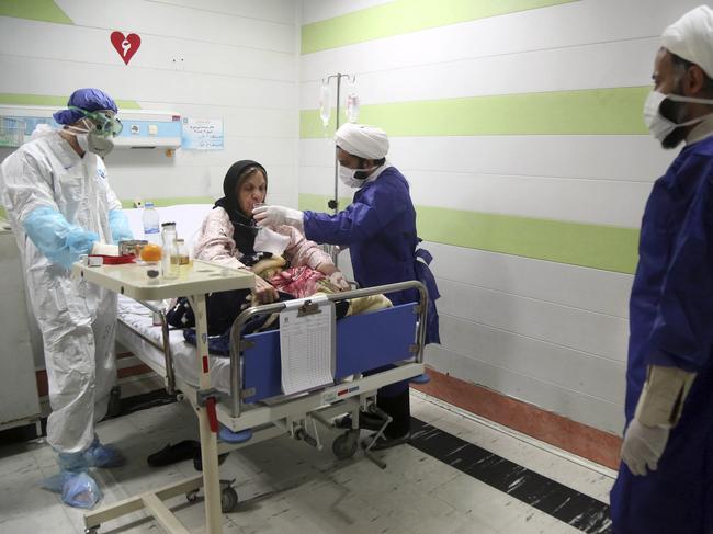 A cleric (right) assists a medic treating a patient infected with the coronavirus, at a hospital in Qom, about 125 kilometres south of the capital Tehran, Iran. Picture: AP