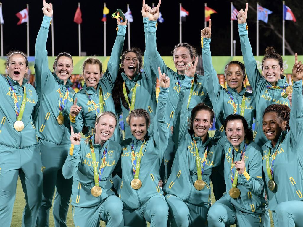 Gold medallists Australia celebrate after the women’s rugby sevens medal ceremony during the Rio 2016 Olympic Games at Deodoro Stadium in Rio de Janeiro on August 8, 2016. / AFP PHOTO / PHILIPPE LOPEZ