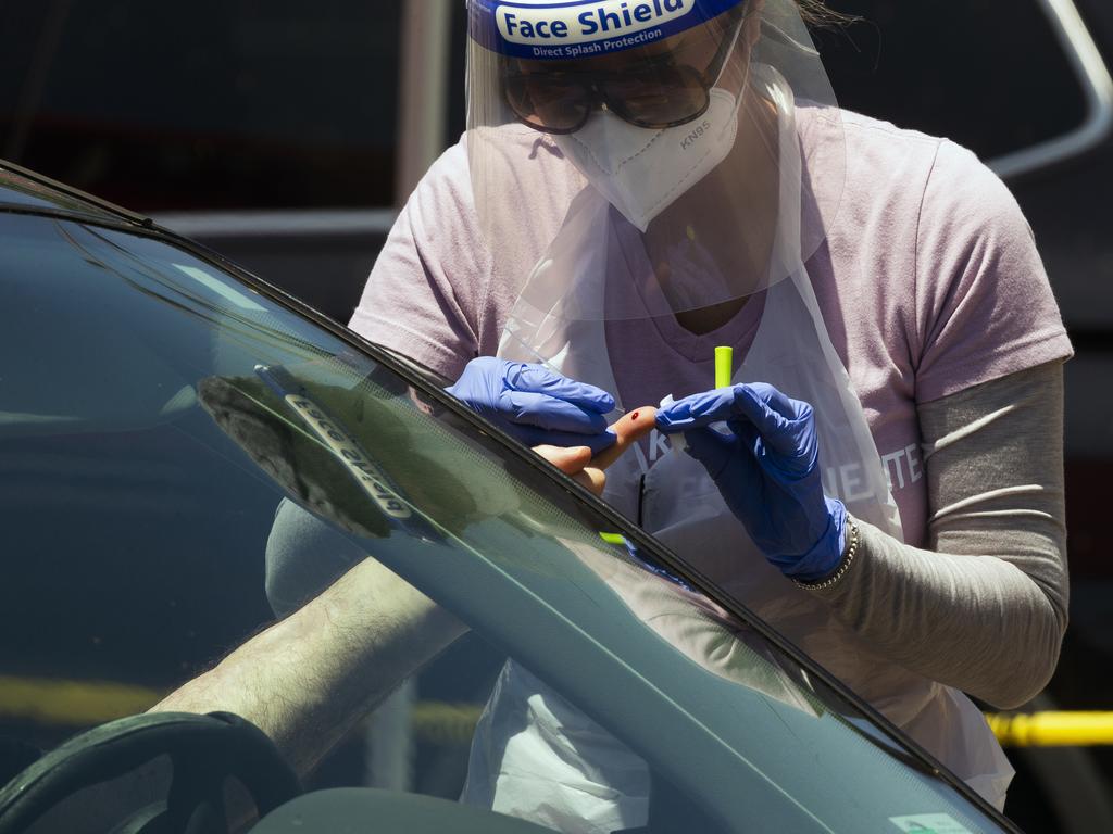 A health worker takes a COVID-19 antibodies blood test at the Homeboy Industries car park in Los Angeles. Picture: Damian Dovarganes/AP