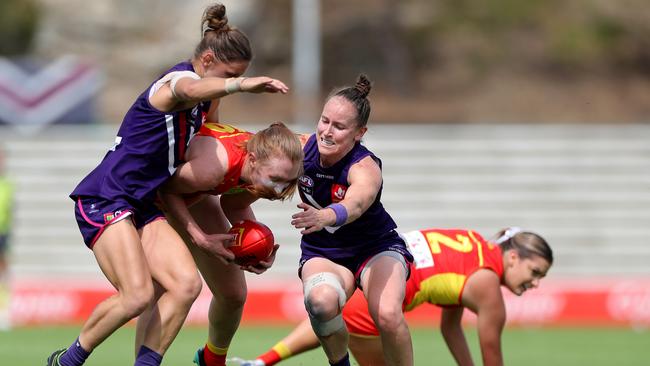 Tiarna Ernst of the Suns is tackled by Kiara Bowers and Kara Antonio of the Dockers during the AFLW semi final 4 match between the Fremantle Dockers and Gold Coast Suns at Fremantle Oval in Perth, Saturday, March 21, 2020. (AAP Image/Richard Wainwright)