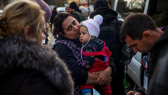 A woman holds her child as they arrive from the Russian-held town of Berdyansk at a humanitarian relief centre in Zaporizhzhia.