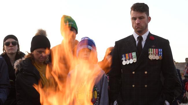 Servicegoers reflect on the occasion at the eternal flame. Picture: William West/AFP