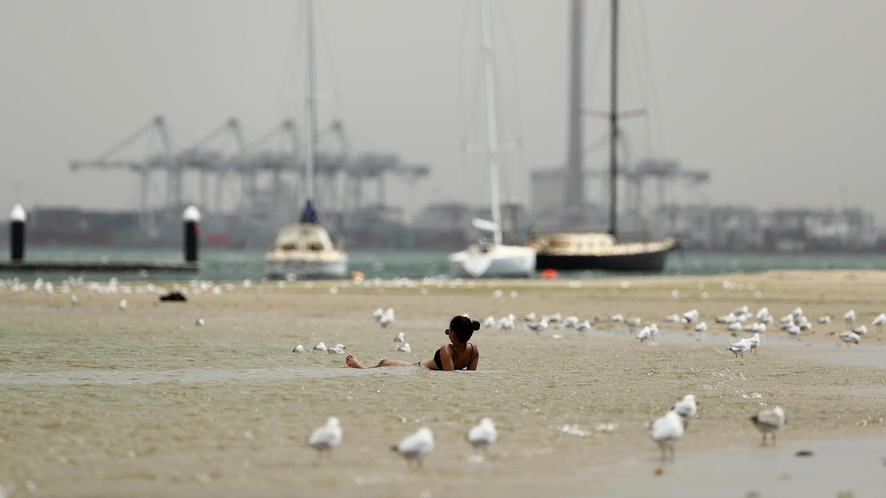 A woman sits in the shallows at St.Kilda Beach. Picture: Robert Cianflone/Getty Images