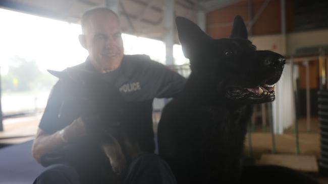 NT Police Dog Operations Unit Senior Constable Steven Dalrymple with the squads newest recruits, Axe and Jax. Constable Dalrymple's canine partner Drax is the puppy's father.