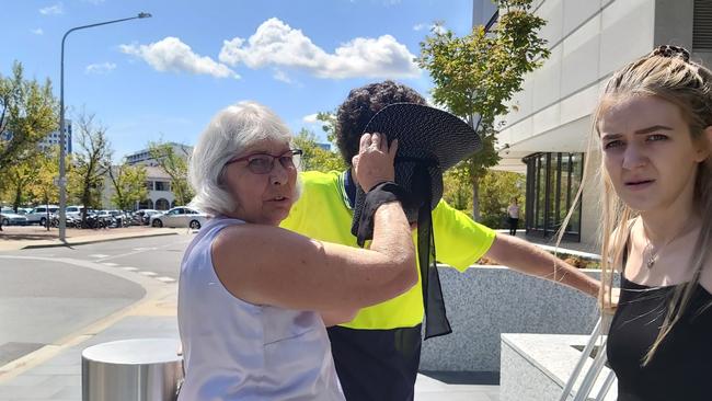 Darcy Edward Page, of Greenway (pictured centre), leaves the ACT Magistrates Court on crutches, accompanied by supporters, after being charged with rape and child sex offences. Picture: Craig Dunlop