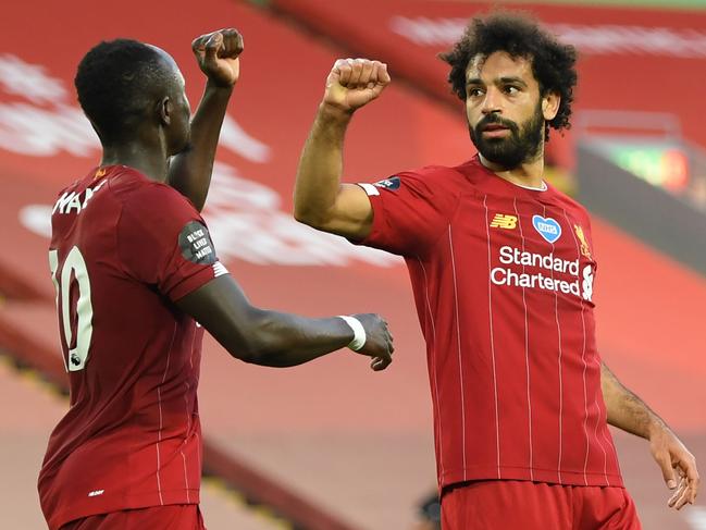 Liverpool's Egyptian midfielder Mohamed Salah (R) celebrates scoring his team's second goal with Liverpool's Senegalese striker Sadio Mane during the English Premier League football match between Liverpool and Crystal Palace at Anfield in Liverpool, north west England on June 24, 2020. (Photo by Shaun Botterill / POOL / AFP) / RESTRICTED TO EDITORIAL USE. No use with unauthorized audio, video, data, fixture lists, club/league logos or 'live' services. Online in-match use limited to 120 images. An additional 40 images may be used in extra time. No video emulation. Social media in-match use limited to 120 images. An additional 40 images may be used in extra time. No use in betting publications, games or single club/league/player publications. /