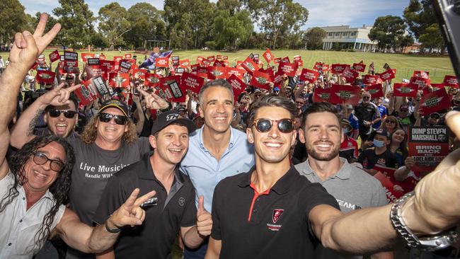 Racing car driver Nick Percat with ( from left) musician Vince from Zep Boys, musician Crafty, Dave Gleeson from the Screaming Jets, fellow race driver Todd Hazelwood, MP Peter Malinauskas, fellow race driver Scott Pye and a crowd of Adelaide 500 race enthusiasts.