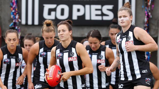 Magpies Stephanie Chiocci and Brianna Davey, right, lead the team on to Victoria Park last weekend. Eddie McGuire said he was proud of his involvement in developing the women’s game. Picture: Getty Images