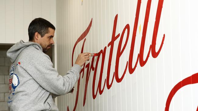 A sign artist puts the finishing touches on branding inside the new Fratelli Fresh restaurant opening in Manly on July 1. Picture: John Appleyard