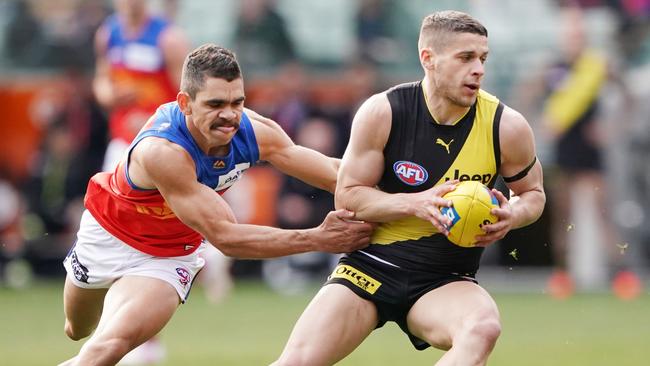 Dion Prestia slips a tackle from Brisbane Lions Charlie Cameron. Picture: AAP Image/Michael Dodge.