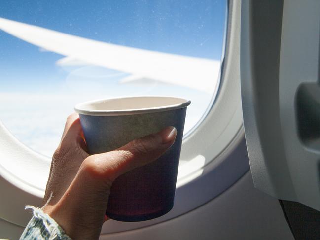 Cropped photo of stewardess holding teapot and paper cup stock photo