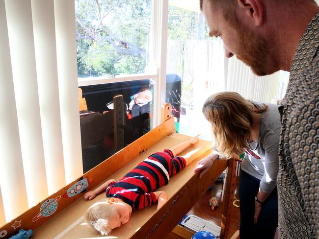 Ina Mills gives son Roki, 3, physical therapy at their Newport home. Picture: Troy Snook