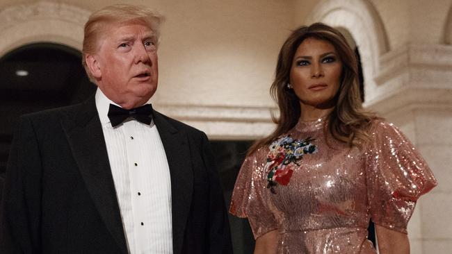 President Donald Trump, center, speaks with reporters as he arrives for a New Year's Eve gala at his Mar-a-Lago resort with first lady Melania Trump and their son Barron, Sunday, Dec. 31, 2017, in Palm Beach, Fla. (AP Photo/Evan Vucci)