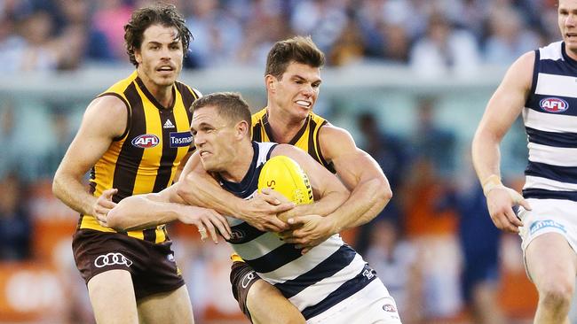 Jaeger O'Meara of the Hawks tackles high Joel Selwood of the Cats.