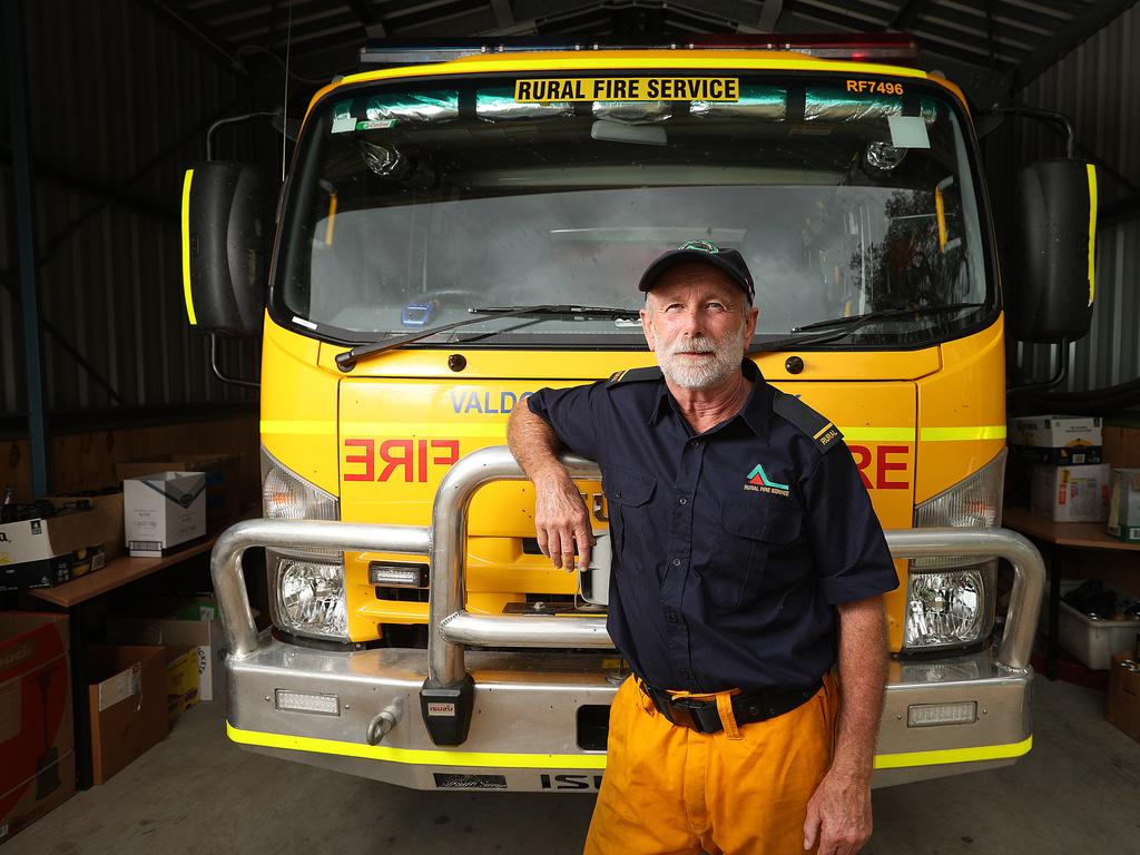 <b>TREVOR WATSON, 61</b> <br/> <i>Valdora/Yandina Rural Fire <br/>Brigade, Sunshine Coast, Qld<br/> Years volunteering: 7</i> <br/>Peregian Beach, a resort town just south of Noosa Heads, usually boasts beaches of soft white sand and unspoilt watersof crystalline clarity. In September and October last year, however, smoke shrouded the landscape and ash-laden waves lapped at the blackened shore. Trevor Watson, a member with the Valdora and Yandina Rural Fire Brigade, arrived at the seaside hamlet as a fast-moving fire tore through bushland and jumped a major road, setting several properties alight. “When it’s so close to so many properties it sort of raises the urgency level,” he, 61, said says. “You are certainly conscious that a lot is at stake.” The paperbark trees, a defining part of the lush coastal oasis, roasted in the extraordinary heat and exploded in showers of embers. “The trees were hitting the ground and virtually combusting, just bursting into flames,” Watson says. Sirens blared as a wall of flame engulfed Peregian Springs, Peregian Breeze and Peregian Beach, while fierce winds stoked a hellish ember storm. “It was like it was raining fire. I’ve never seen anything like that.” Police went door to door, evacuating panicked residents as the blaze tore through a part of Queensland more accustomed to tropical downpours than raging firestorms. Remarkably, only one home was lost in the series of bushfires that menaced the holiday hotspot from September last year until Christmas Day. Watson’s brigade patrolled the streets for two days after the initial onslaught had passed on September 9, dousing rogue spot fires. “The job doesn’t end when the fire calms down,” he says. “Just one ember is enough to spark an entirely new fire.” Picture: Lyndon Mechielsen