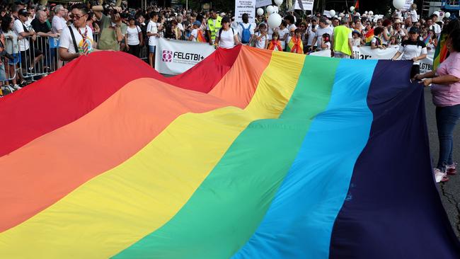 Participants display a rainbow-coloured flag before taking part in the parade of the LGBTIQIA+ (lesbian, gay, bisexual, transgender, intersex and queer) Pride in Madrid on July 1, 2023. (Photo by Pierre-Philippe MARCOU / AFP)