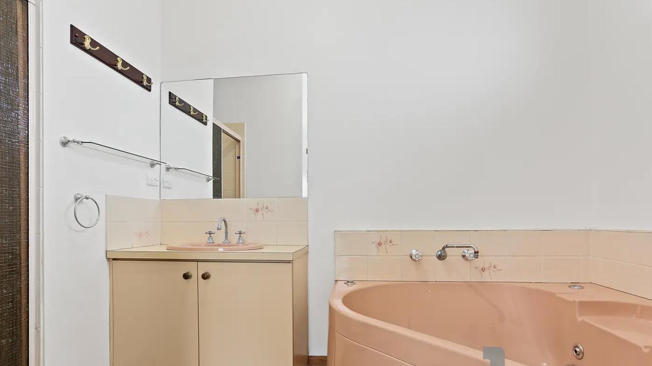 Bathroom: Before a dated 1980s style bathroom with a pink bath