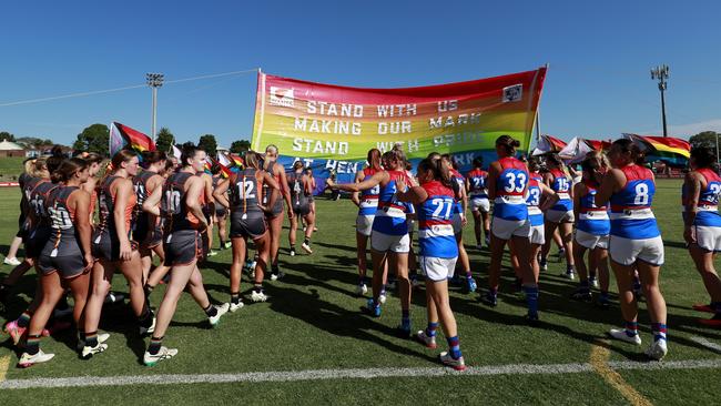 The Bulldogs an Giants run through a joint Pride Round banner. Picture: Dylan Burns/AFL Photos