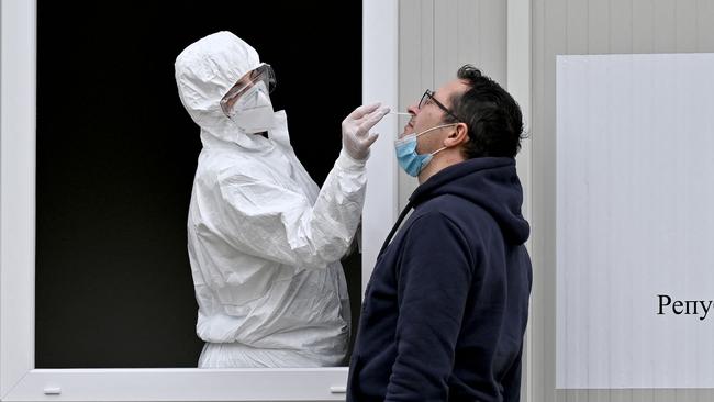 (FILES) A medical worker takes a sample with a swab from a man, during a coronavirus test, at the Institute of Virology, Vaccines and Sera âTorlakâ in Belgrade on December 24, 2020. Five years since Covid-19 started upending the world, the virus is still infecting and killing people across the globe -- though at far lower levels than during the height of the pandemic. Here is the current state of the play. (Photo by Andrej ISAKOVIC / AFP)