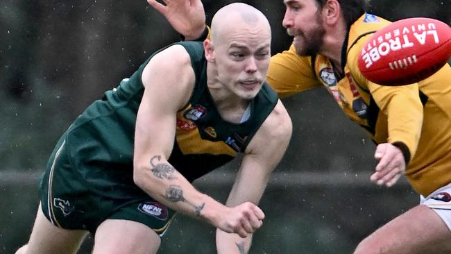 Bradley Johnstone fires out a handball for Old Eltham Collegians. Picture: Andy Brownbill