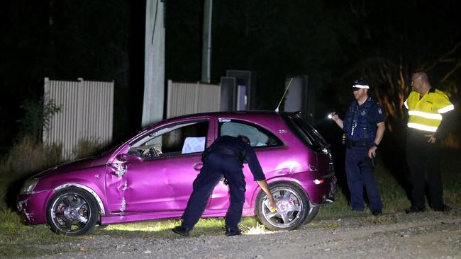 Police inspect the car believed to be involved in the shooting incident at a property in Pimpama. Photo: Regi Varghese