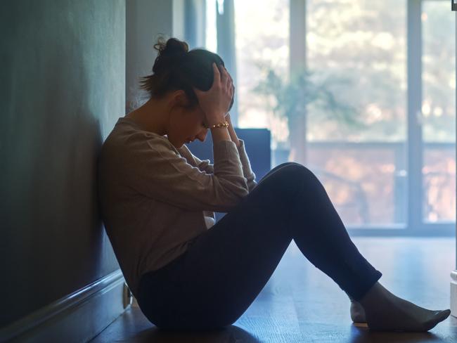 istock generic:  woman, abuse, DV, domestic violence, harassment, sexual harassment.   Sad Young Woman Sitting on the Floor In the Hallway of Her Appartment, Covering Face with Hands. Atmosphere of Depression, Trouble in Relationship, Death in the Family. Dramatic Bad News Moment . Picture: istock