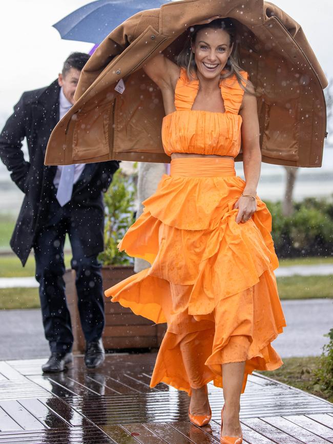 Racegoers escape the bad weather in Melbourne. Picture: Jason Edwards