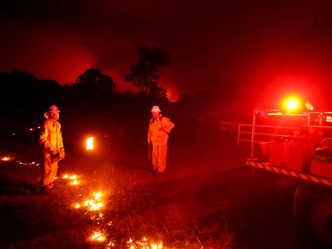 Daily Telegraph. Bushfires move through the town of Tingha in northern NSW. RFS officers take advantage of the calm winds to put  in a backburn to protect a farm house  Pic Nathan Edwards