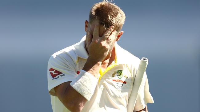 A dejected David Warner walks off the field.