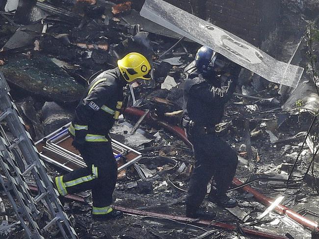 ‘Tell them to get out now.’ Firefighters on the scene of a devastating fire that raged in a high-rise apartment building in London. Picture: AP