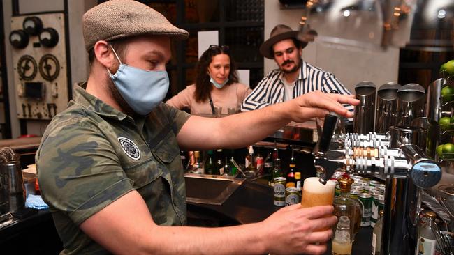 People celebrate in a bar in Melbourne as one of the world’s most locked-down cities reopens. Picture: AFP