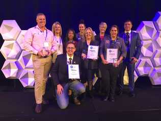 ACHIEVEMENT: Accepting their eAwards are Darling Downs Health staff members (from left) Rodney Nesbitt, Michelle Cleary, Tess Wootton, (front, kneeling) Dr Daniel Halliday, Sally Norton, Lorraine McMurtrie, Denise Pambid of Darling Downs and West Moreton PHN and Karen Johnson with judge Rupert Lee from the Australian Digital Health Agency.