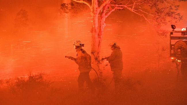 Firefighters battle embers in windy conditions during bushfires near Nowra in NSW in December 2019. Picture: AFP