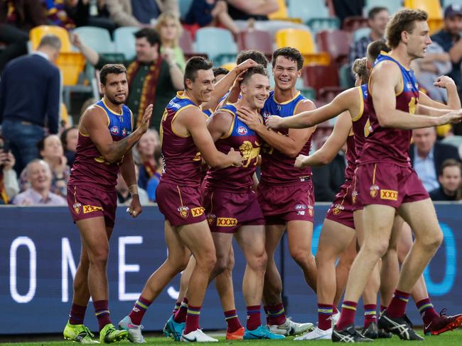 Linc McCarthy (centre) is congratulated by Lions teammates after kicking a goal against Geelong. Picture: Russell Freeman/AFL Photos via Getty Images