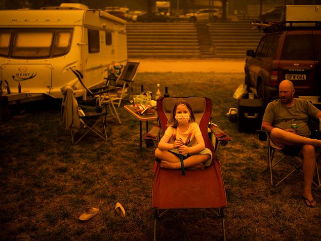 Amy (L) and Ben Spencer sit at the showgrounds in the southern New South Wales town of Bega where they are camping after being evacuated from nearby sites affected by bushfires on December 31, 2019. - Thousands of holidaymakers and locals were forced to flee to beaches in fire-ravaged southeast Australia on December 31, as blazes ripped through popular tourist areas leaving no escape by land. Picture: Davey/AFP