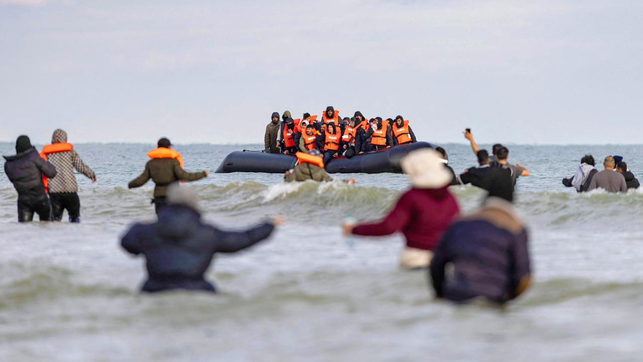 Migrants wave to a smuggler’s boat from the beach of Gravelines, near Dunkirk, in an attempt to cross the English Channel. This follows the tragic loss of five lives, including a seven-year-old girl, amid new asylum policies. Picture: Sameer Al-Doumy/AFP