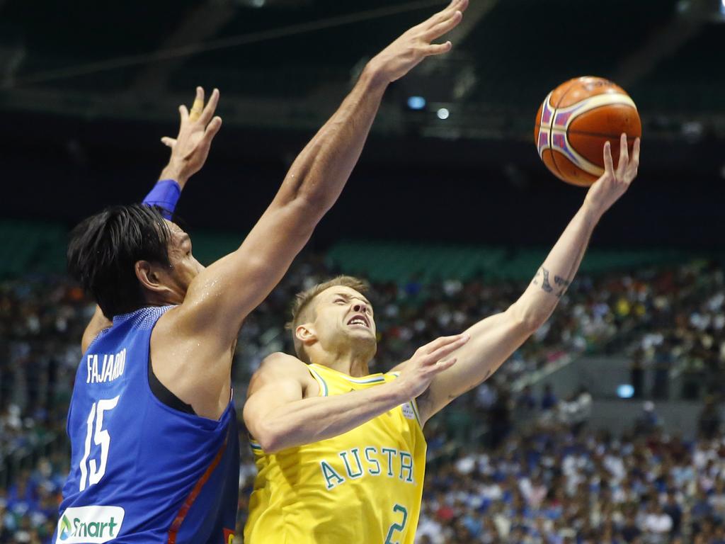 Australia's Nathan Sobey scores a lay-up as the Philippines' June Mar Fajardo defends during the FIBA World Cup Qualifiers Monday, July 2, 2018 at the Philippine Arena in suburban Bocaue township, Bulacan province north of Manila, Philippines. Australia defeated the Philippines 89-53 via default following a brawl in the third quarter. (AP Photo/Bullit Marquez)