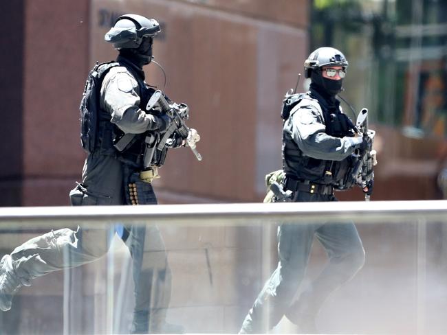 Heavily armed police run away from building during one of their many drills during the day. Picture: Adam Taylor