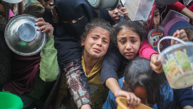 Citizens queue for food that is cooked in large pots and distributed for free during war-time on December 28, 2023 in Rafah, Gaza. Picture: Ahmad Hasaballah/Getty Images