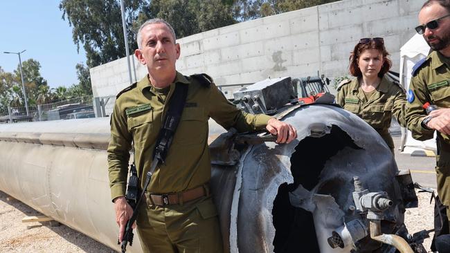 An sraeli military spokesman, Rear Admiral Daniel Hagari, left, with the wreckage of an Iranian ballistic missile which fell during the weekend attack. Picture: AFP