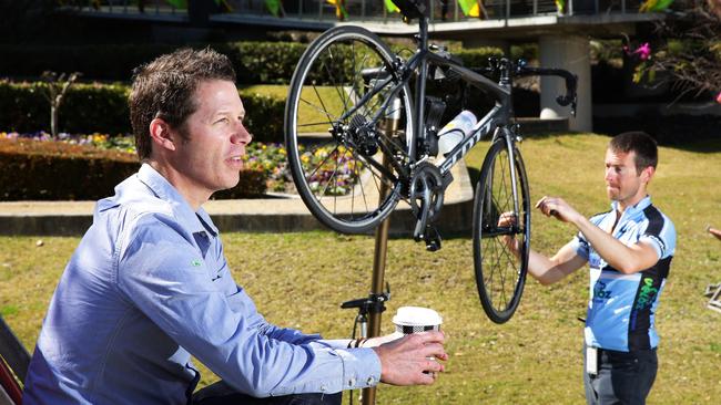 Optus employee James Leech enjoys a drink while mechanic Karlo Bozic works on his bicycle. Picture: Virginia Young