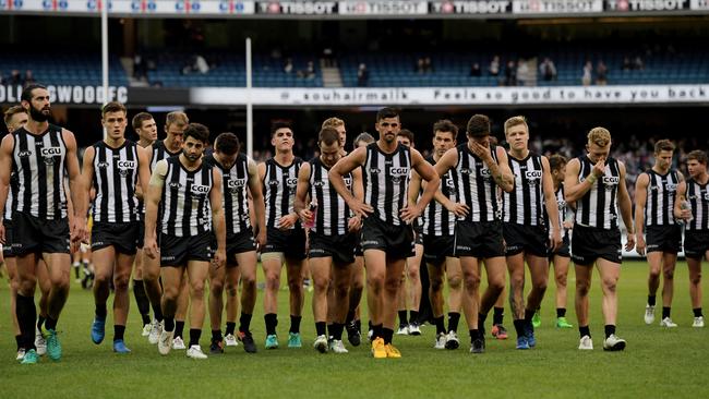 Collingwood players walk off the MCG after losing to Carlton.