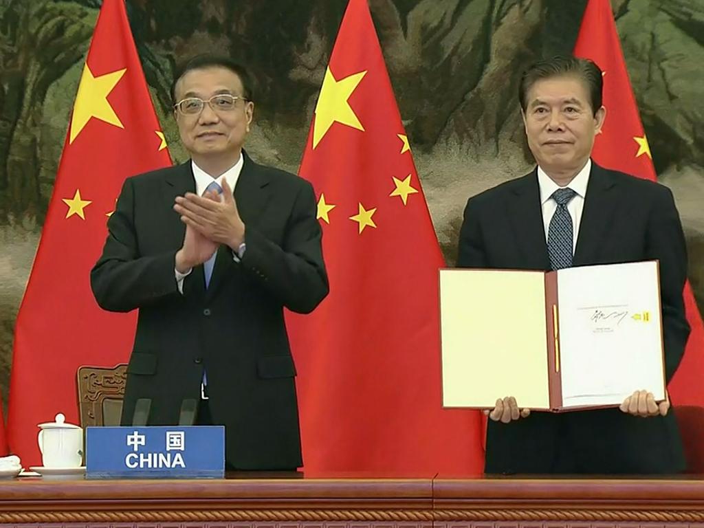 China’s Premier Li Keqiang and Chinese Minister of Commerce Zhong Shan holds up the agreement during the signing ceremony at the summit, hosted in Hanoi. Picture: Vietnam Host Broadcaster / AFP